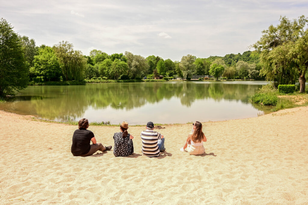 Groupe d'amis sur la plage au bord du plan d'eau